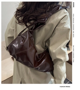 Détail d'un grand sac bandoulière plissé marron foncé avec une bandoulière nouée distinctive
