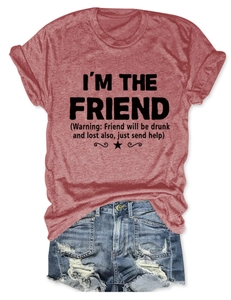 Dettaglio della t-shirt rosso mattone con scritta I'M THE FRIEND e shorts in jeans strappati