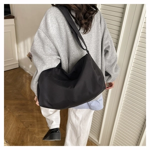 Close-up of black waterproof nylon sports bag with wide adjustable shoulder strap detail