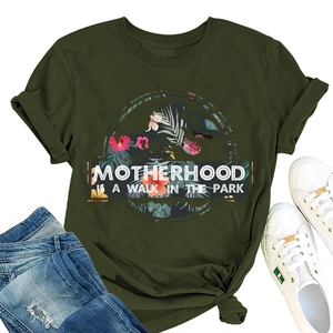Dettaglio di maglietta verde in cotone con stampa dino floreale e testo Motherhood