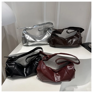 Gros plan de quatre sacs plissés en couleurs argent, marron, noir et bordeaux