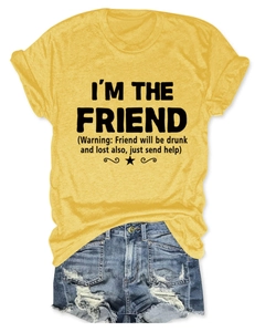 Dettaglio della maglietta gialla con la scritta nera 'I'm the friend' in stile casual