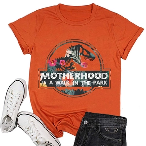 Flat lay della t-shirt arancione Motherhood con scarpe bianche e pantaloncini neri di jeans