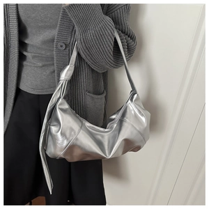 Close-up of a silver metallic hobo bag featuring a knotted shoulder strap and sleek finish