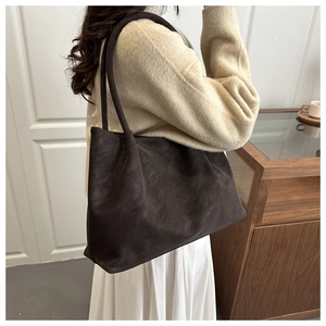 Dettaglio della borsa tote vintage in pelle scamosciata marrone con focus su capienza