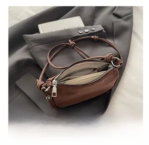 Detailed interior of a brown matte leather crossbody bag showing spacious inner compartment