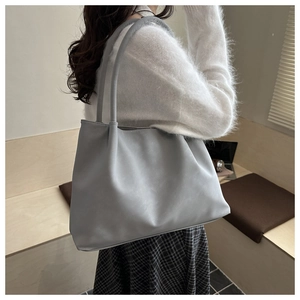 Vista dettagliata di una borsa tote grigia in pelle con consistenza morbida e grande capacità