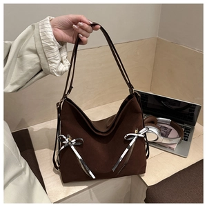 Détail du sac cabas marron foncé avec nœud décoratif à carreaux et poches zippées