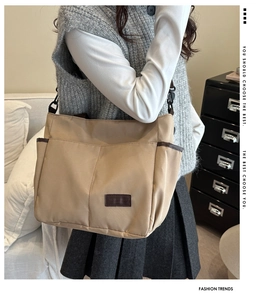 Dettaglio di una borsa tote in tela beige con tasche laterali e patch in pelle moda