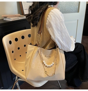 Dettaglio della borsa tote jacquard leopardo beige con catena di perle e dettagli oro