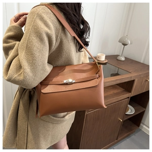 Détail du sac bandoulière en cuir caramel avec son fermoir rotatif métallique chic