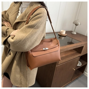 Détail d'un sac à bandoulière en cuir marron avec boucle rotative argentée et sangle