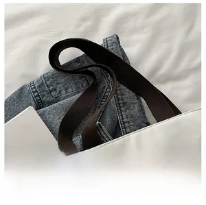 Dettaglio borsa tote bianca con manici intrecciati marroni e cuciture pulite