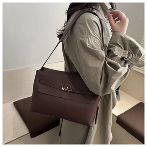 Détail d'un sac à bandoulière en cuir marron foncé avec boucle métallique et rabat