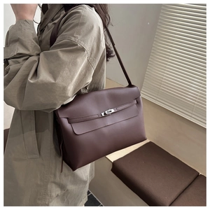 Détail du sac bandoulière en cuir mat marron foncé avec fermoir tournant en métal