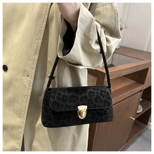 Détail du sac baguette léopard rétro avec boucle dorée et texture mate élégante