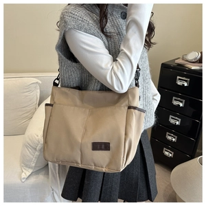 Dettaglio della borsa tote in tela kaki con toppa in pelle e tracolla regolabile