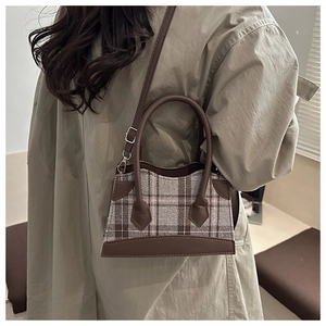 Détail du sac à main rétro en patchwork de cuir marron et plaid avec bandoulière réglable