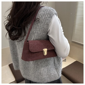 Détail du sac baguette bordeaux avec gaufrage léopard et fermoir doré brillant