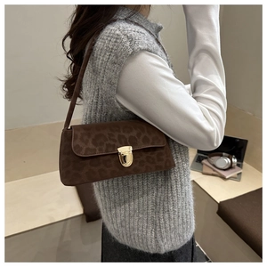 Vue détaillée du sac à bandoulière léopard avec fermoir rotatif doré et texture en daim doux