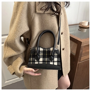 Détail du sac bandoulière en tweed à carreaux avec garniture en cuir noir et poignée