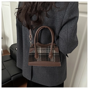 Détail du sac bandoulière en laine à carreaux marron avec poignées en cuir chic