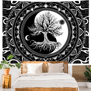 Detail of black and white Tree of Life mandala tapestry hung above a cozy bed with plants