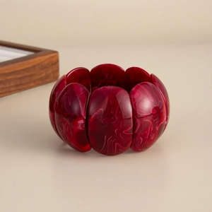 Detailed macro of dark red marble resin stretch bracelet with vintage acrylic texture