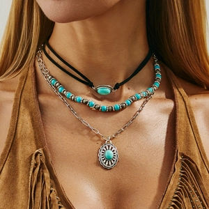 Detail of bohemian layered necklace with turquoise beads and vintage silver pendant