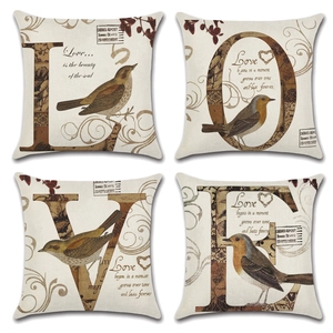 Dettaglio di quattro federe vintage in lino con motivi di uccelli e scritte LOVE retrò