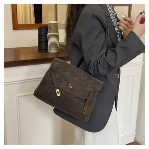 Dettaglio di grande borsa vintage con chiusura dorata e raffinata trama in pelle