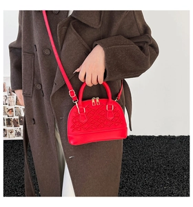 Detail der roten Ledertasche mit aufwändiger Stickerei und goldenem Reißverschluss-Akzent