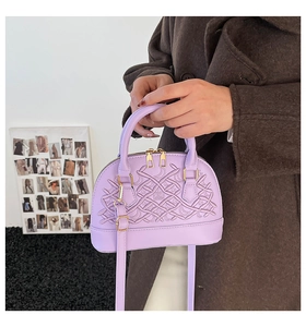 Detailansicht der bestickten lavendelfarbenen Muscheltasche mit goldenen Beschlägen