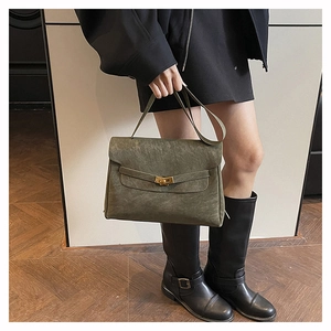 Dettaglio borsa a mano in pelle scamosciata verde scuro con fibbia in metallo dorato