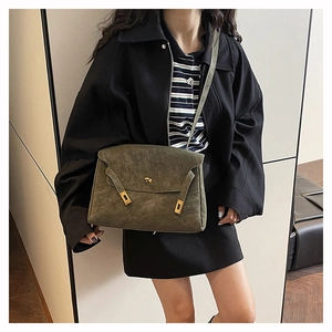 Dettaglio borsa tote in pelle scamosciata verde scuro con fibbia dorata lucida