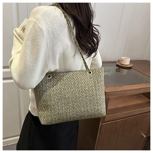 Close-up of multicolor tweed weave shoulder bag with gold leather chain strap