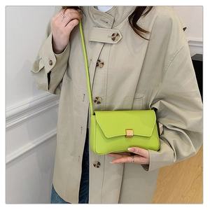Dettaglio borsa baguette verde fluo con fibbia in metallo dorato e trama liscia in PU