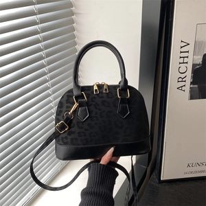 Fashionable black leopard print shell bag with leather base and gold hardware zipper