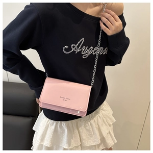Roze laksnoer crossbodytas met zilveren ketting getoond op een model