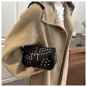 Detail of black punk shoulder bag with silver rivets and metallic buckle strap