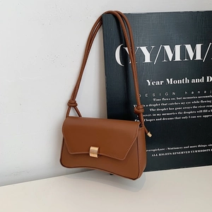 Borsa baguette in pelle marrone con dettaglio tracolla a nodo e chiusura dorata su bianco