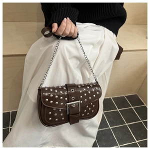 Nahaufnahme der braunen Lackleder-Schultertasche mit Nieten und großer Schnalle