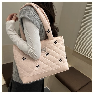 Borsa tote trapuntata rosa con fiocchi ricamati neri e ciondolo in metallo argento