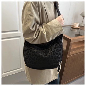 Détail du sac bandoulière croissant à motif léopard noir en nylon haute densité