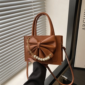 Sac bandoulière en cuir marron avec grand nœud et chaîne de perles élégante