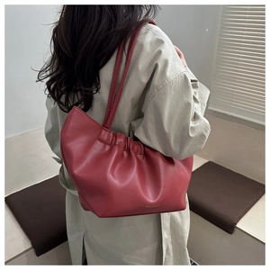 Detail of soft dark red tote bag with elegant pleats and fashion branding
