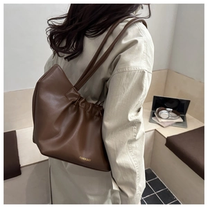 Detail van de koffiebruine leren wolkentas met goudkleurige Fashion Bags belettering