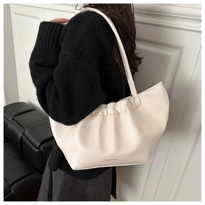 Close-up of cream pleated tote bag with FASHION BAGS logo and shoulder strap