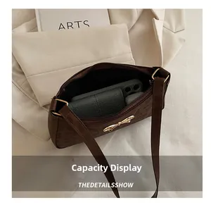 Detail showing inner capacity of dark coffee shoulder bag with bow buckle and daily items