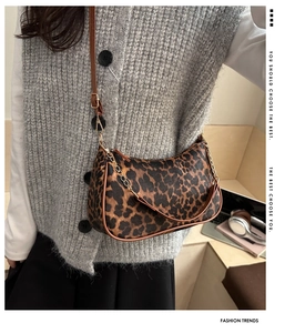 Dettaglio borsa a mezzaluna con stampa leopardata, tracolla in pelle e catena su modella